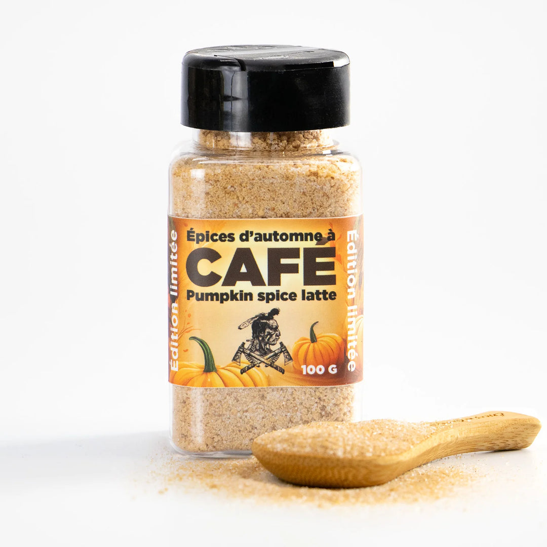 Bottle of pumpkin spice latte coffee spices with a wooden spoon on a white background